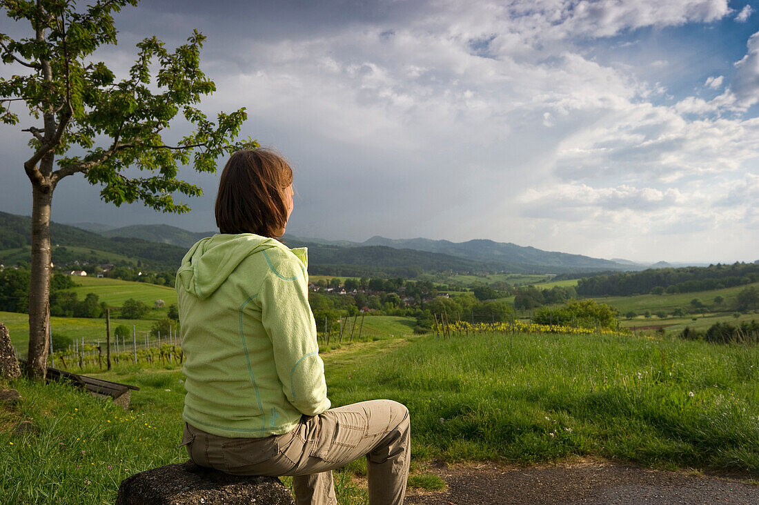 Woman sitting on a stone, Hexental, Black Forest, Baden-Wuerttemberg, Germany, Europe