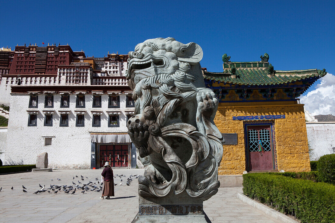 Lion statue in front of the Potala Palace, residence and government seat of the Dalai Lamas in Lhasa, Tibet Autonomous Region, People's Republic of China