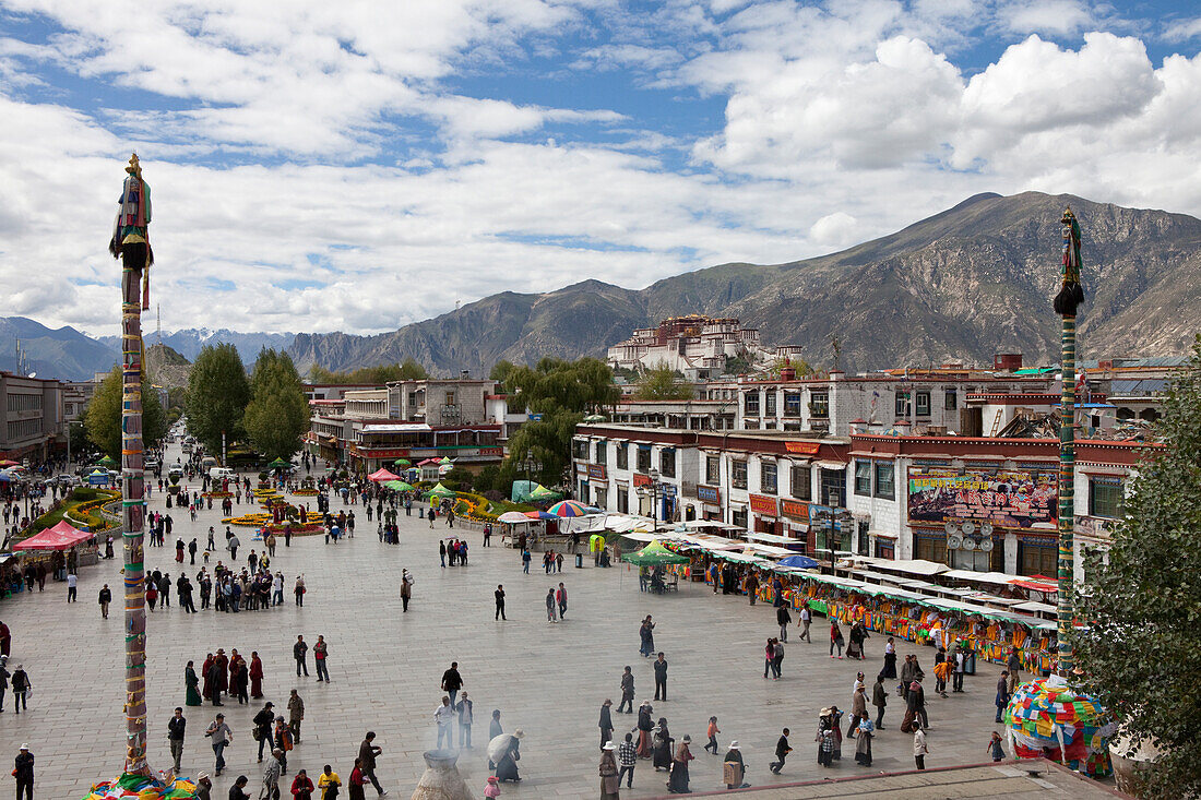 Barkhor Platz mit Pilgern in der Altstadt von Lhasa, Potalla Palast im Hintergrund, autonomes Gebiet Tibet, Volksrepublik China