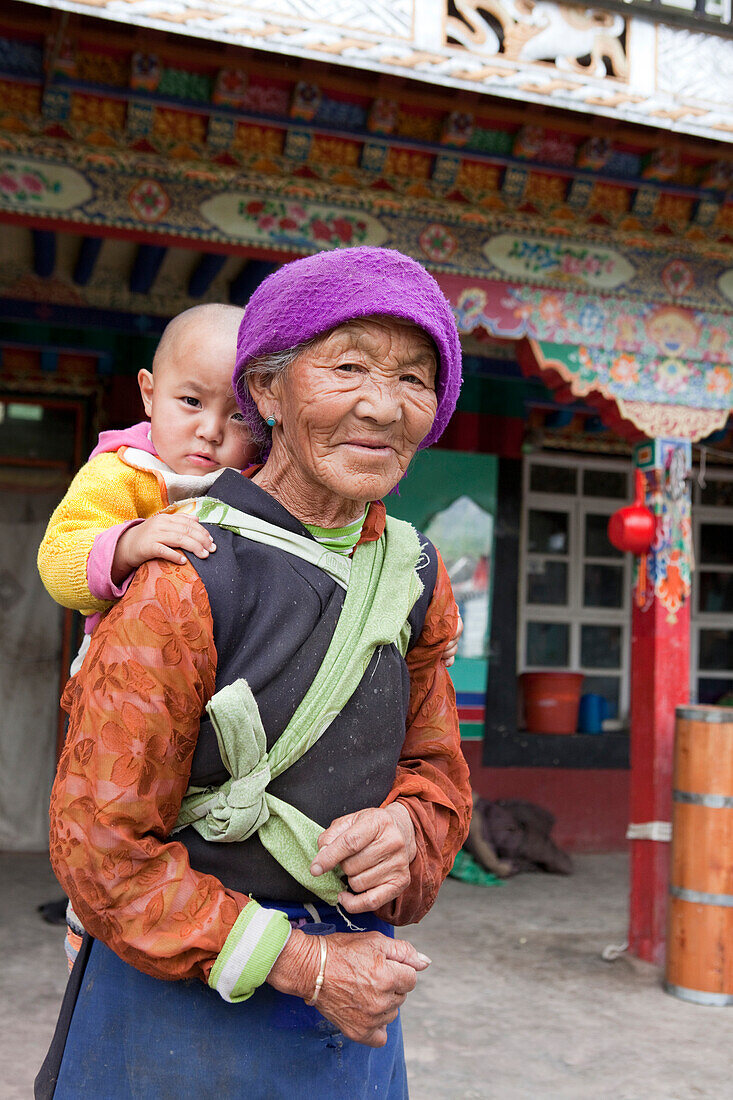 Alte tibetische Bäuerin mit Baby in Lhasa, autonomes Gebiet Tibet, Volksrepublik China