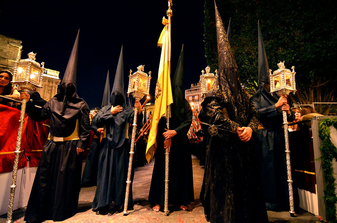 Nazarenos in black cowls on Palm Sunday at night, Semana Santa, Sevilla, Andalusia, Spain, Europe