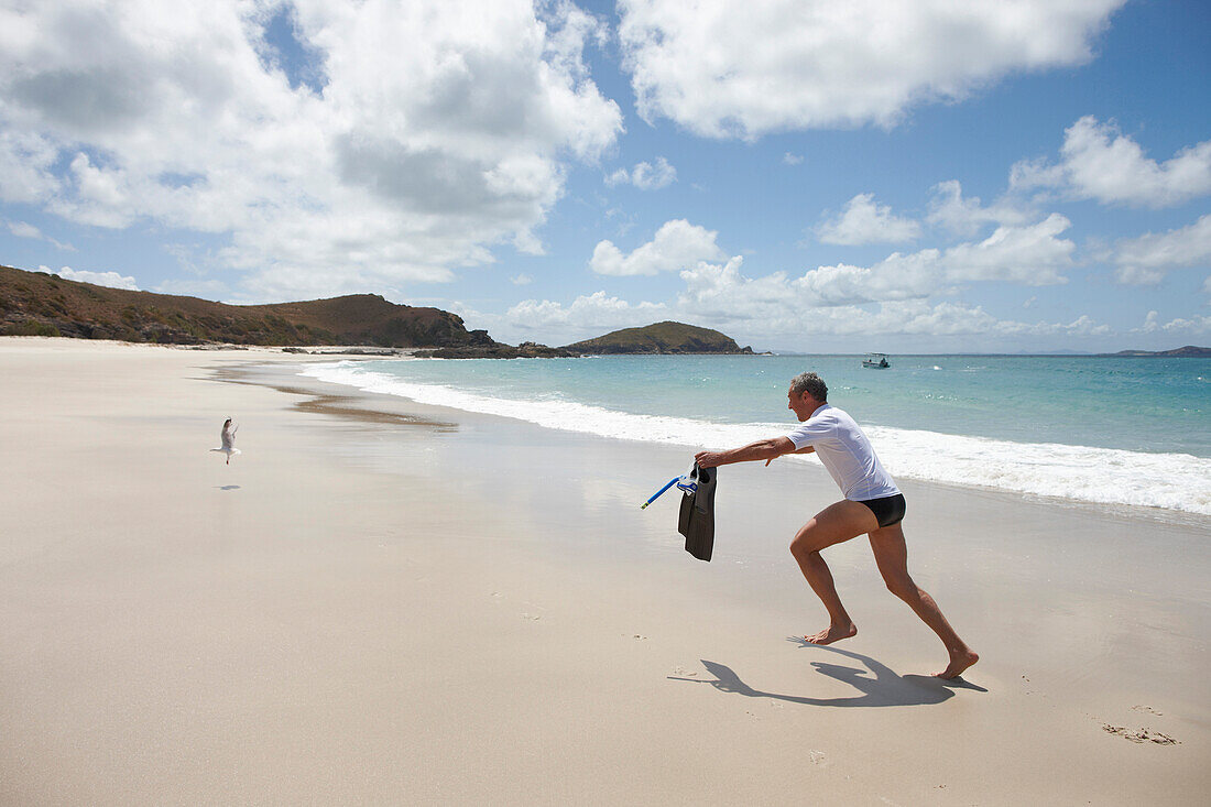 Tourist with snorkelling gear on Middle Island beach, Island next to Great Keppel Island, Great Barrier Reef Marine Park, UNESCO World Heritage Site, Queensland, Australia
