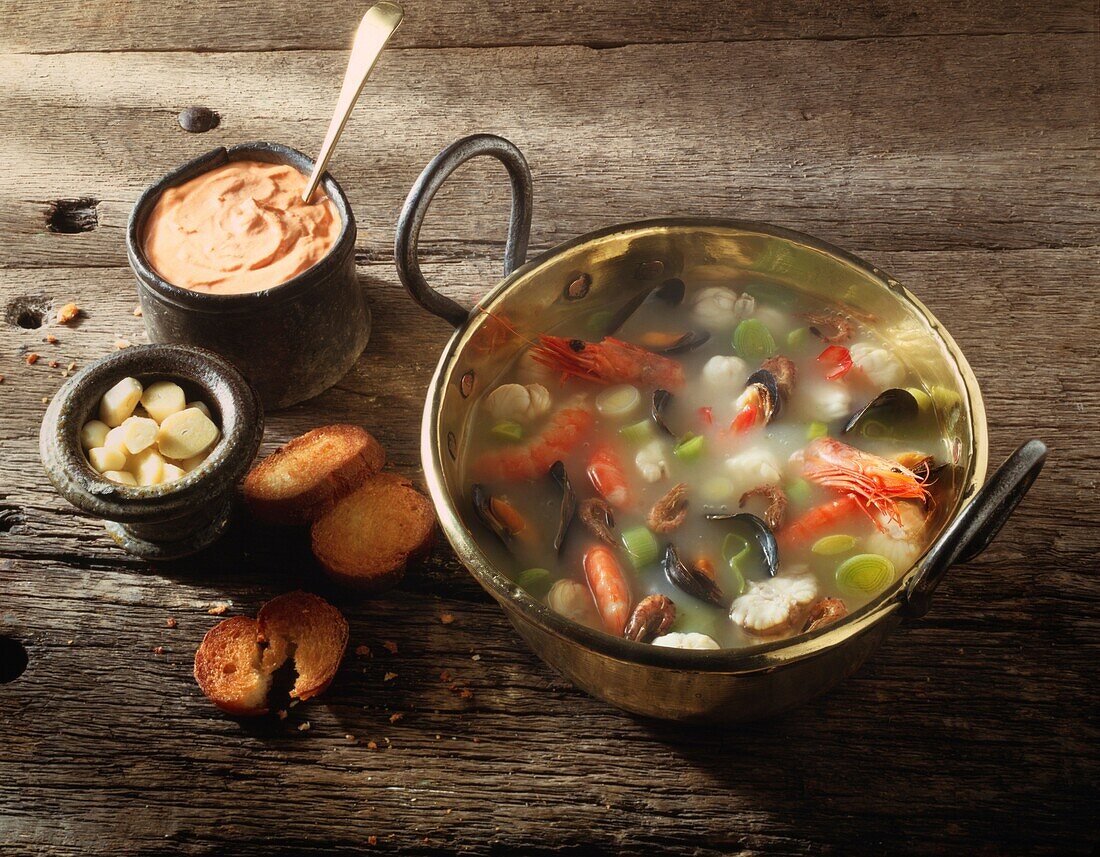 Classic French Bouabaise in a copper pan on a wood background