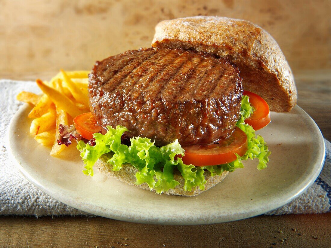 Beef burger in a wholemeal bun with salad and french fries