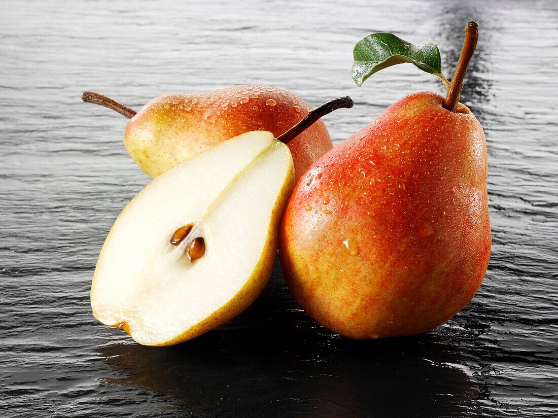 Fresh pears whole and cut with leaves