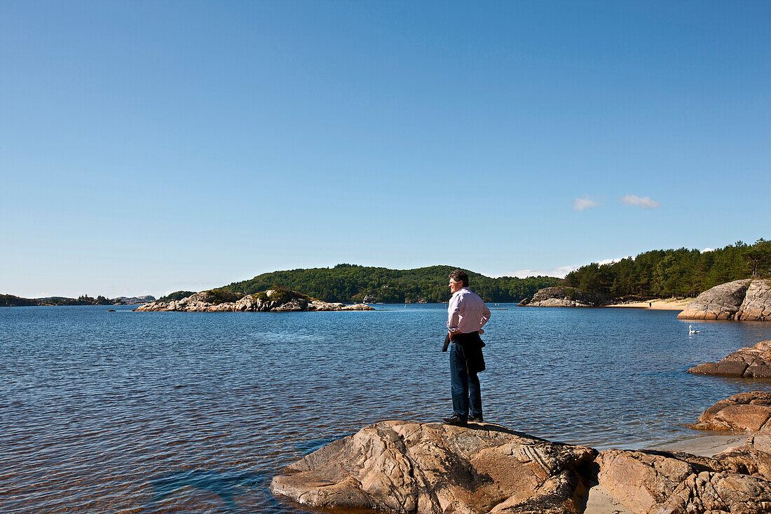 Älterer Mann schaut aufs Meer, älterer Mann geniesst die Meeresluft, Tourist, Landschaft, Küste bei Mandal, Vest-Agder, Süd Norwegen, Skandinavien, Europa