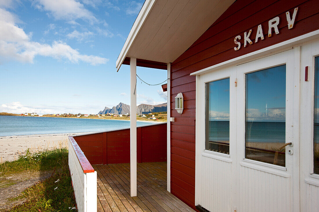 Red wooden house with view towards Ramberg beach, Flagstadoy, Lofoten, Nordland, Norway, Scandinavia, Europe