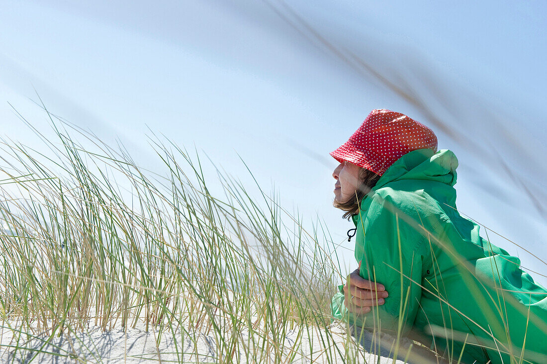 Woman lying on dune, Sylt, Schleswig-Holstein, Germany