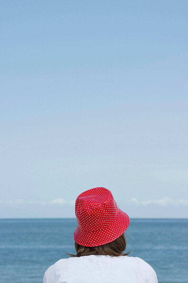 Frau mit Hut sitzt am Strand, List, Sylt, Schleswig-Holstein, Deutschland