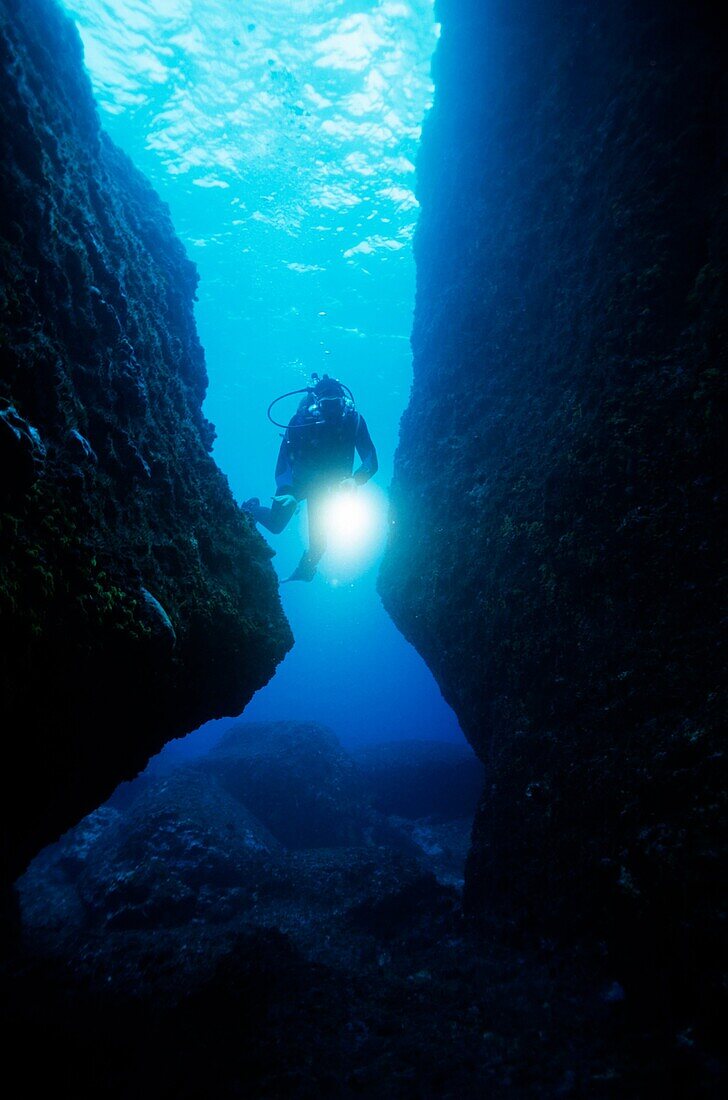 France marseille cave scuba diver shines an underwater light