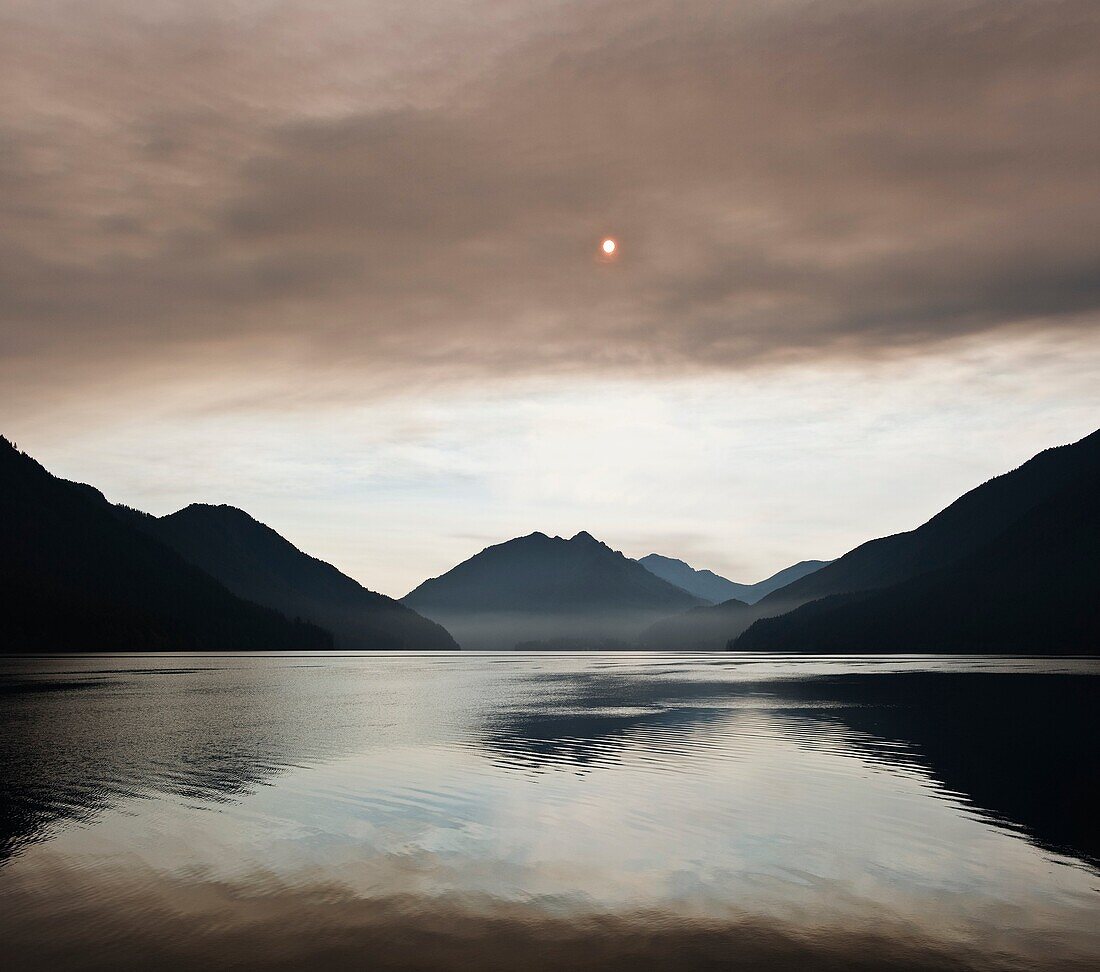 Smoke blocks sun over Lake Crescent, Olympic national park, Washington, USA