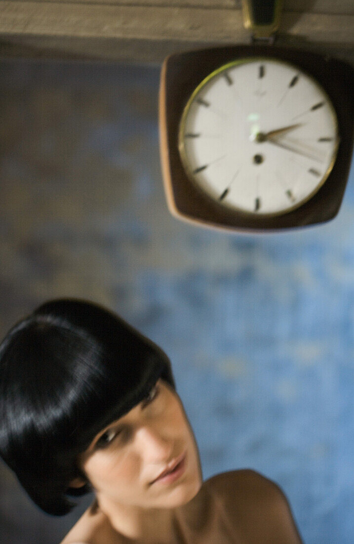 Woman beneath clock, head and shoulders