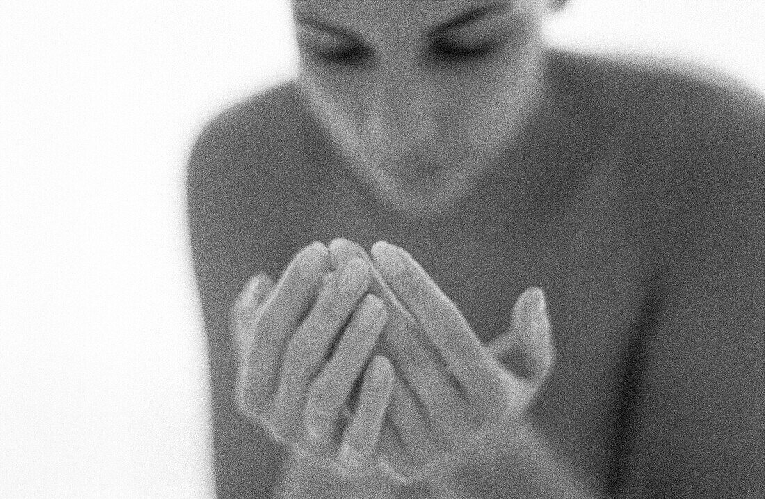 Nude woman cupping hands, b&w
