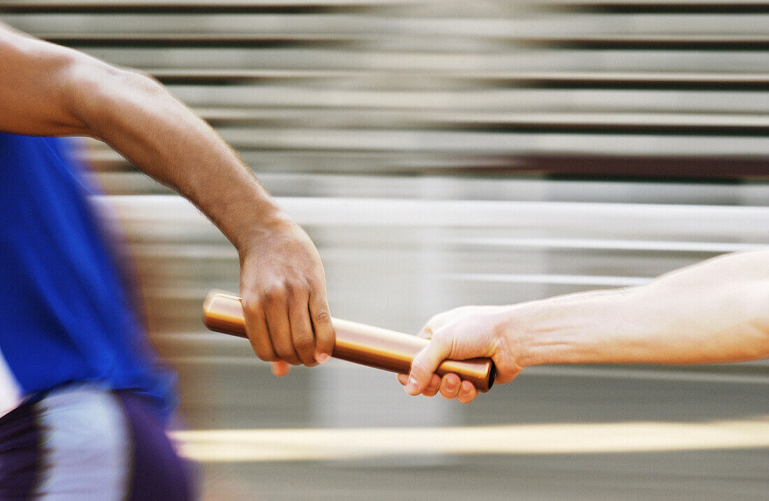 Athletes passing relay baton