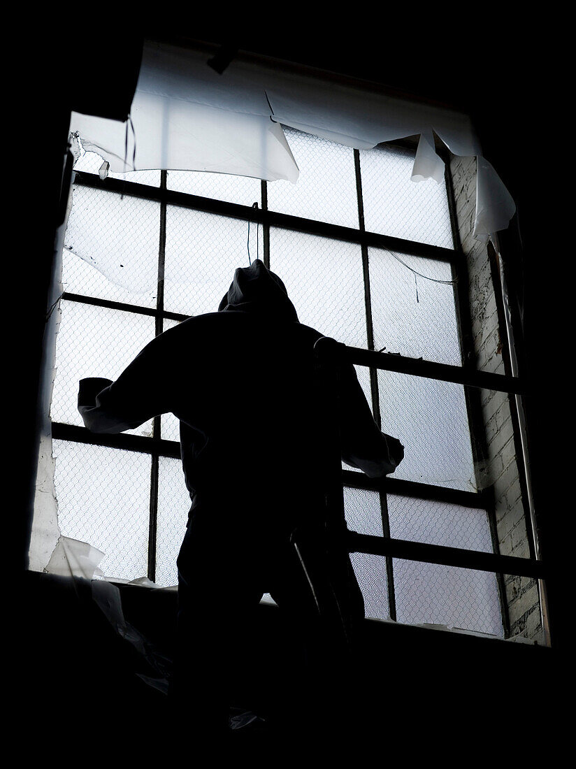 Hooded Figure by Industrial Window
