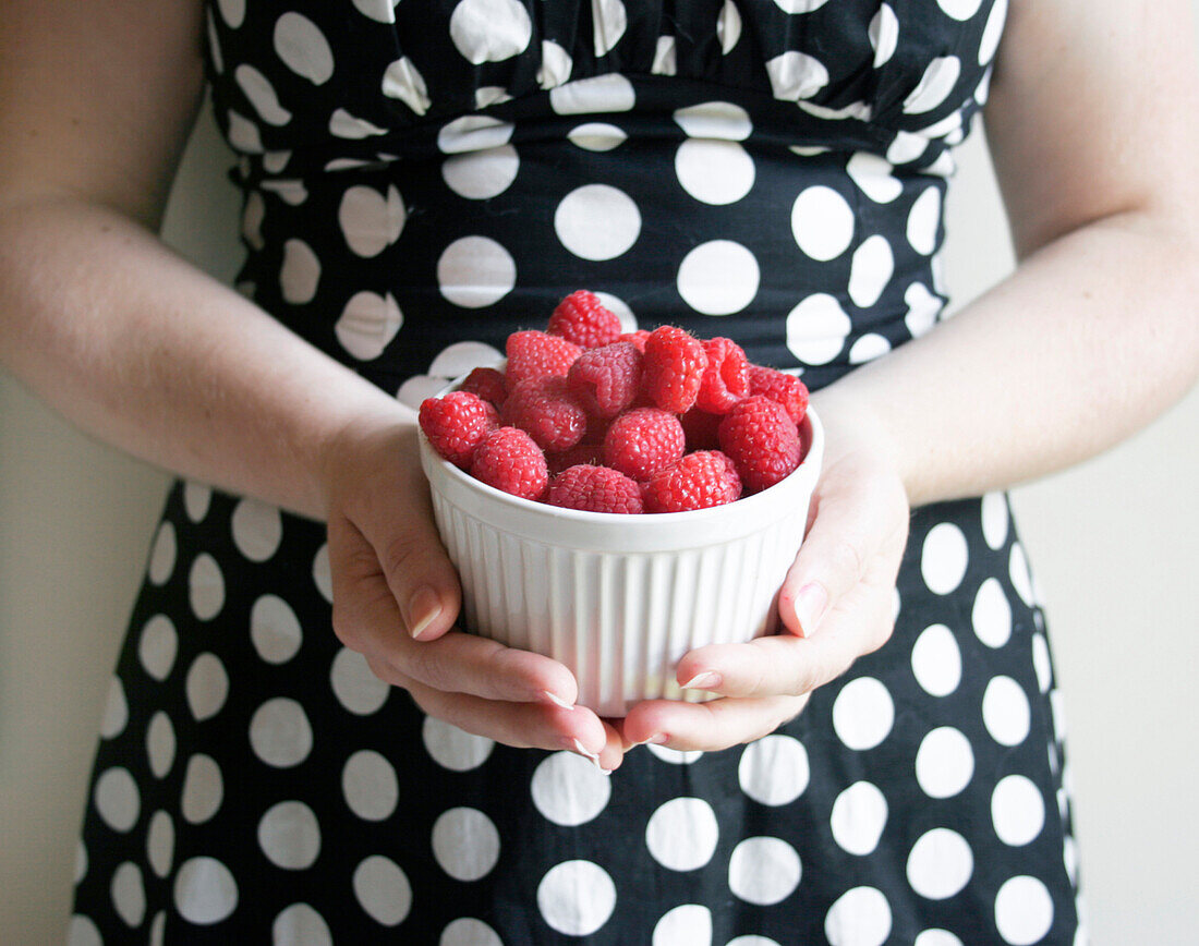 Woman in Polka Dots Holding Bowl of Raspberries