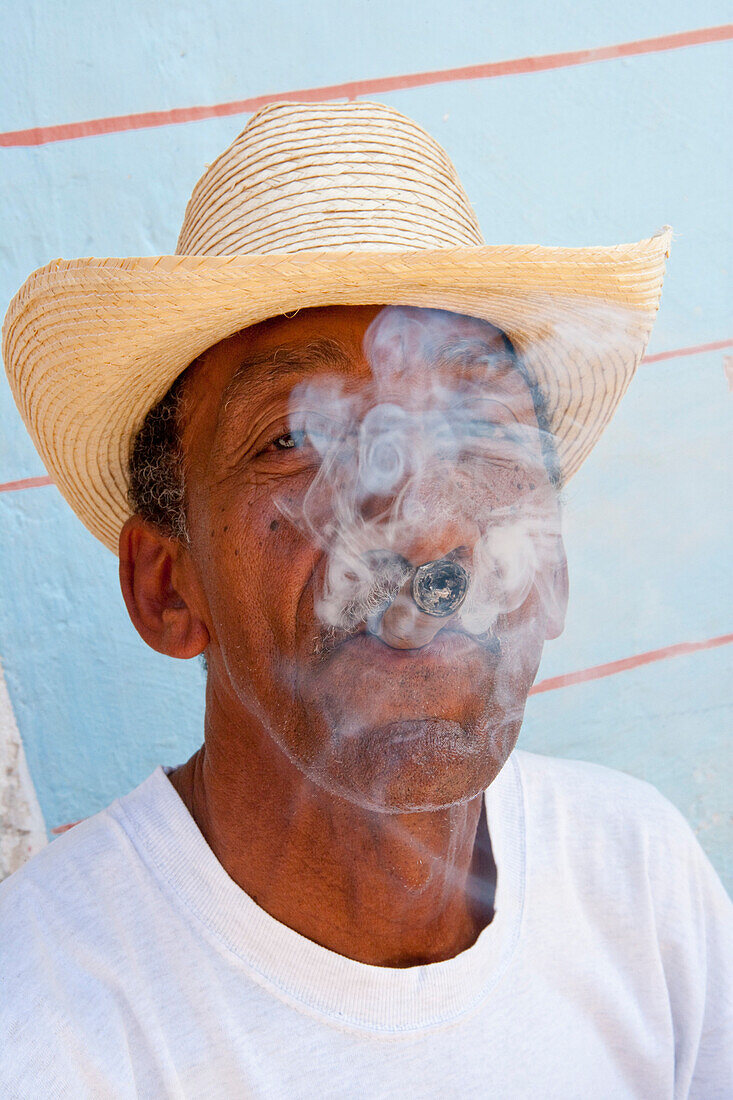 Mann raucht Zigarre in der Altstadt von Trinidad, Provinz Sancti Spiritus, Kuba, Karibik