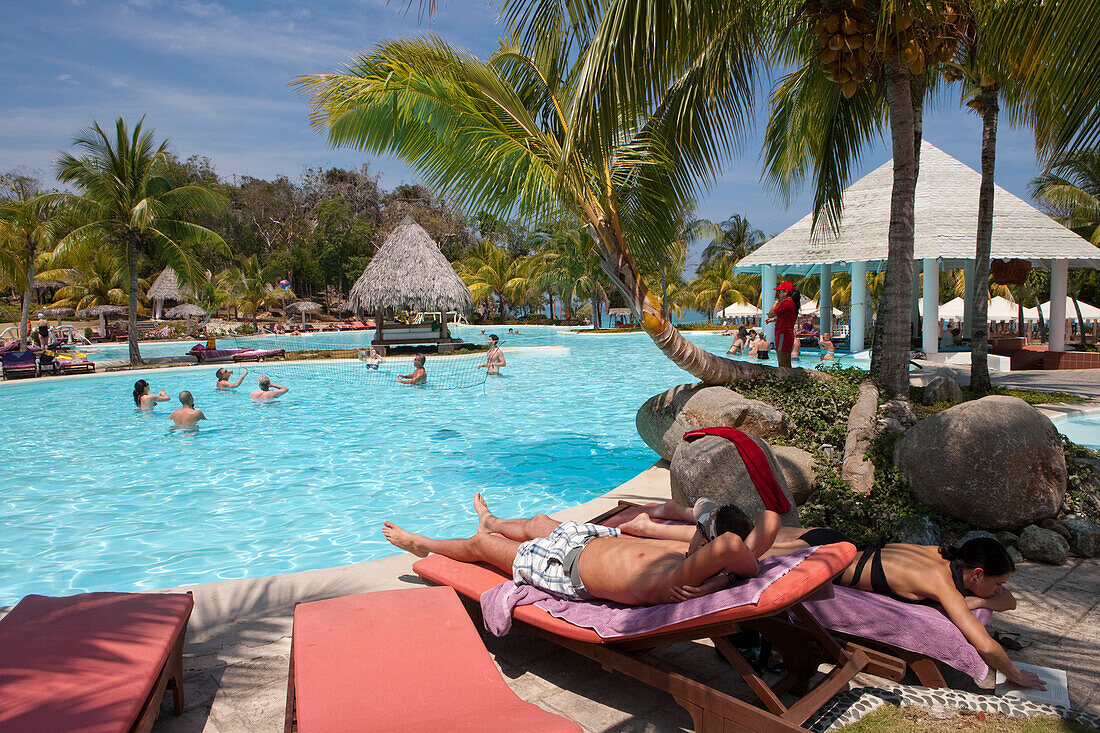 Couple relaxing by the swimming pool at Paradisus Rio de Oro resort, Playa Esmeralda, Guardalavaca, Holguin, Cuba