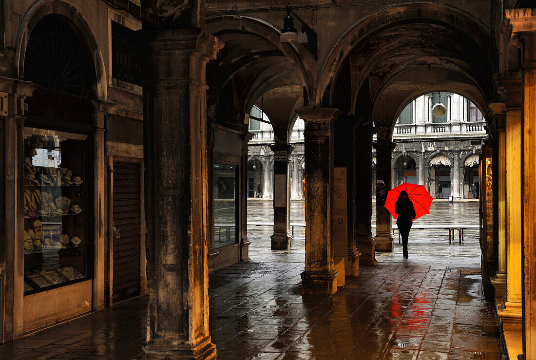 Eine Frau mit rotem Regenschirm, Durchgang zum Markusplatz, Venedig, Italien