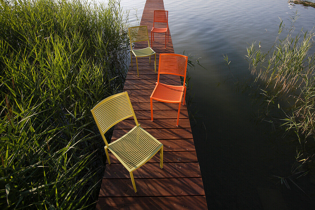 Bunte Stühle auf Steg, Simssee, Bayern, Deutschland