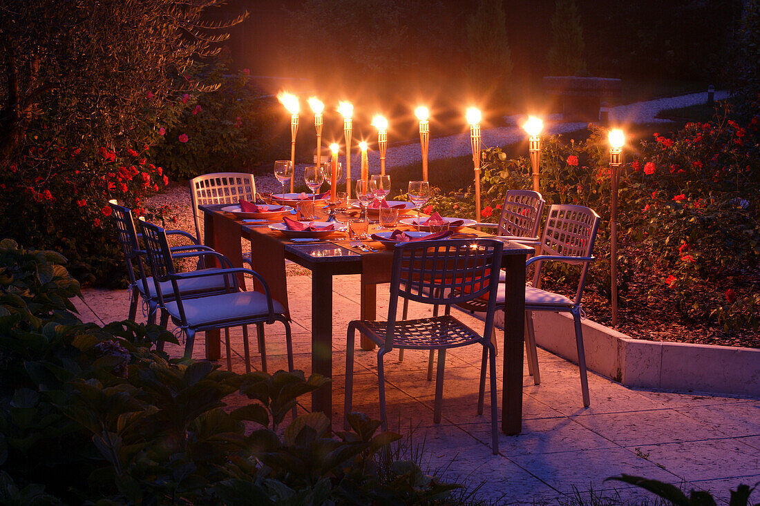 Gedeckter Gartentisch mit Fackeln im Abendlicht, Bayern, Deutschland
