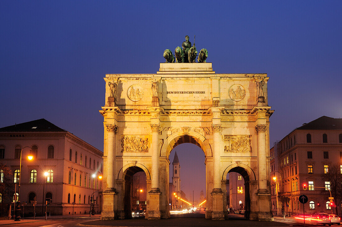 Illuminated Siegestor gate with Ludwigstrasse and Ludwigskirche in the background, Munich, Upper Bavaria, Bavaria, Germany, Europe