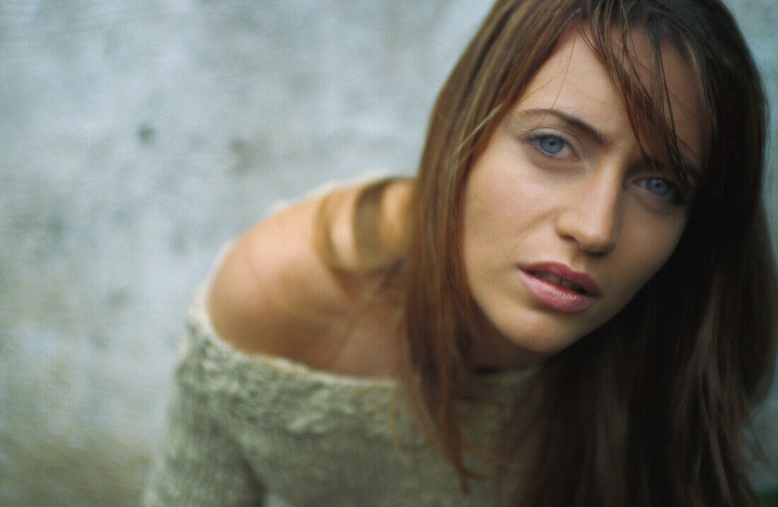 Young woman looking up at camera, high angle view, portrait