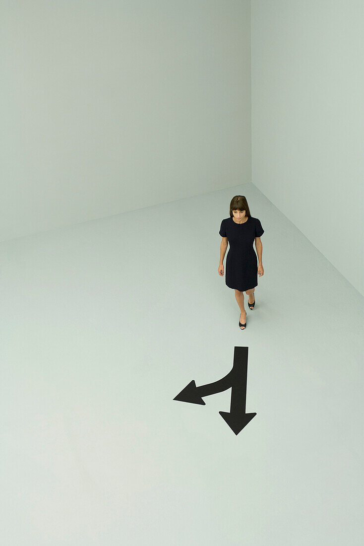 Woman walking, arrows pointing different directions, high angle view