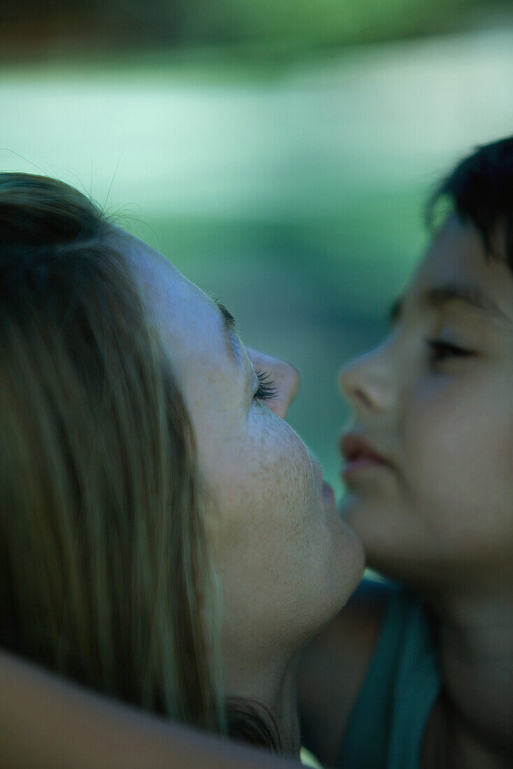 Mother and son embracing, touching chins, close-up