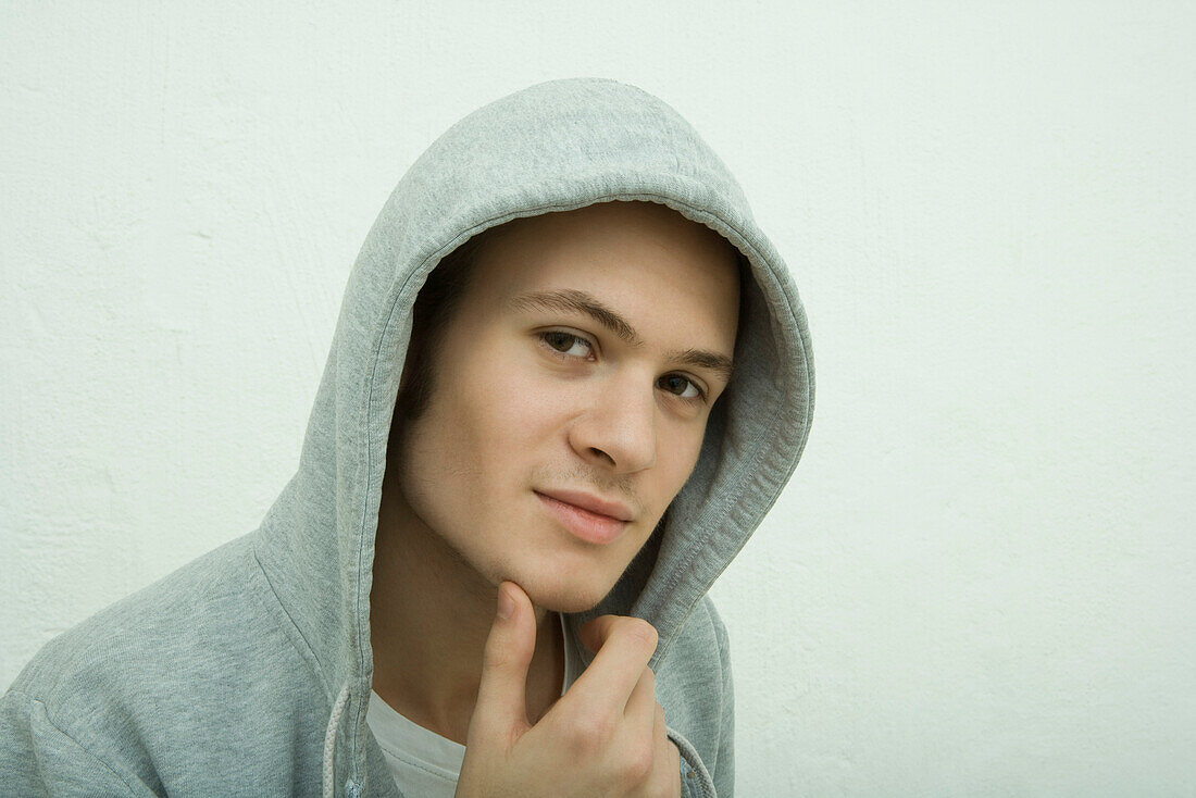 Young man wearing hooded sweatshirt, portrait