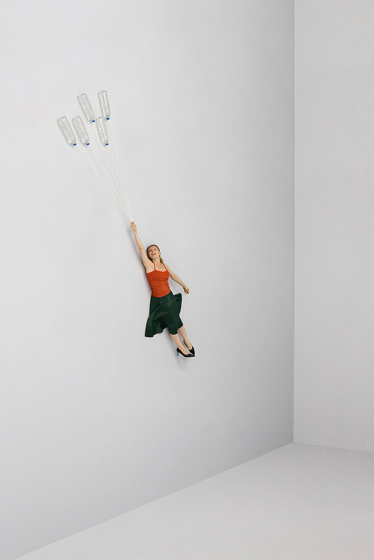Woman flying away, held aloft by water bottles
