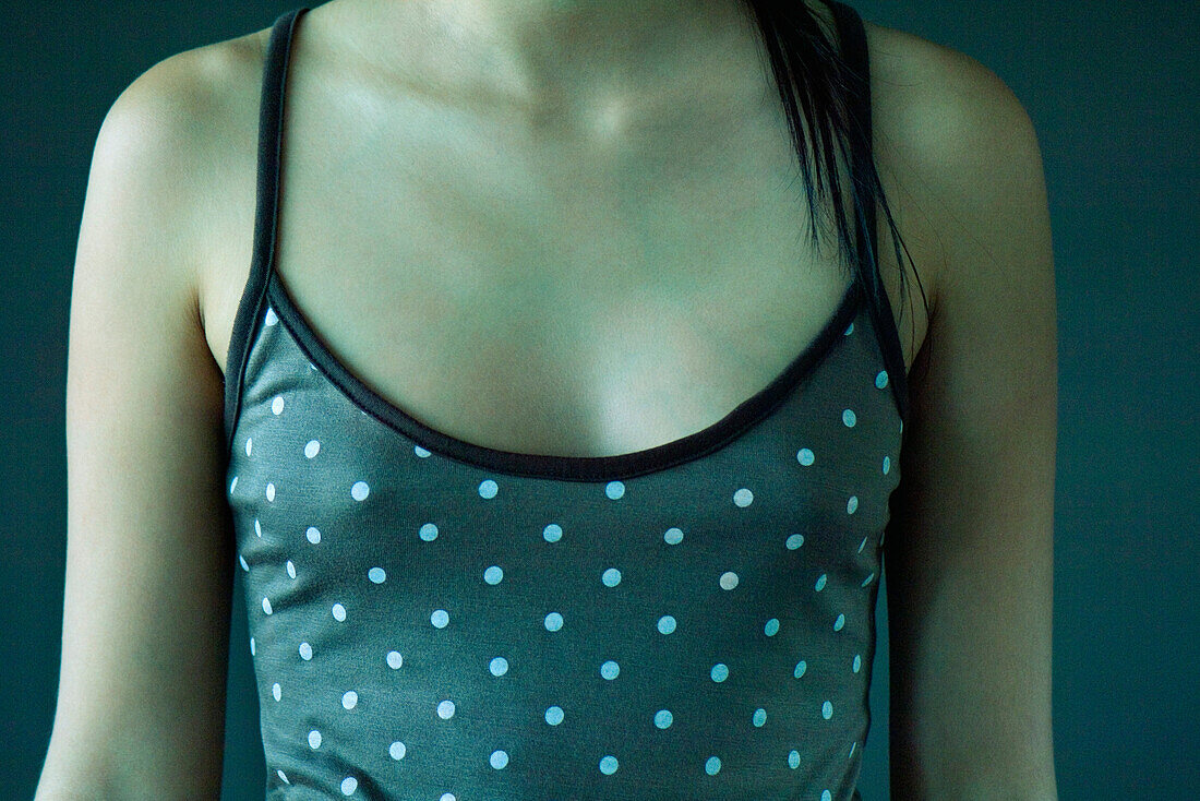 Teenage girl wearing polka dot tank top, cropped