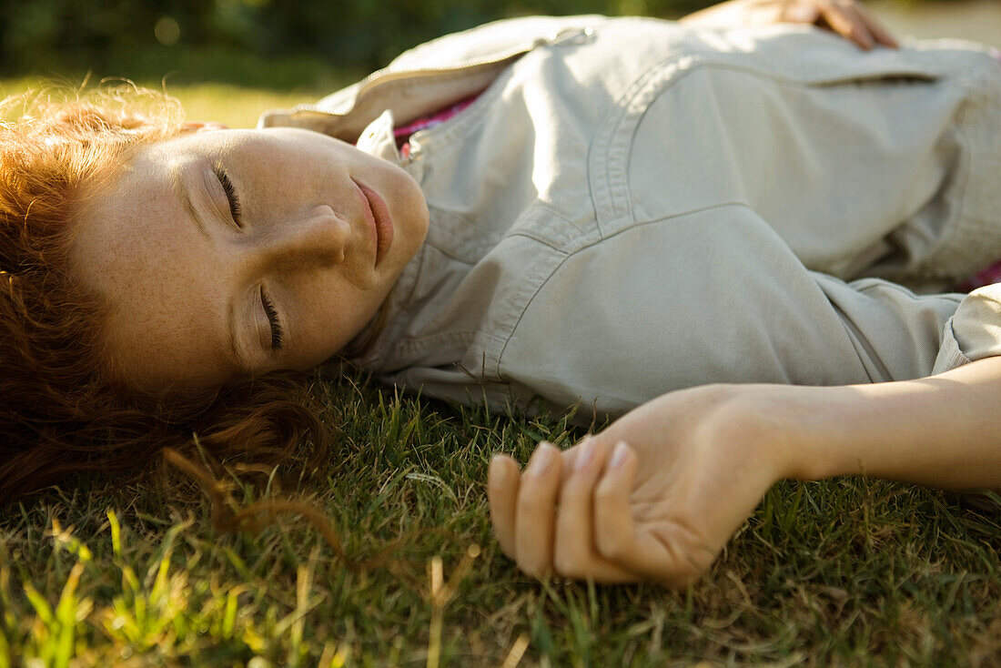 Woman lying on back in grass
