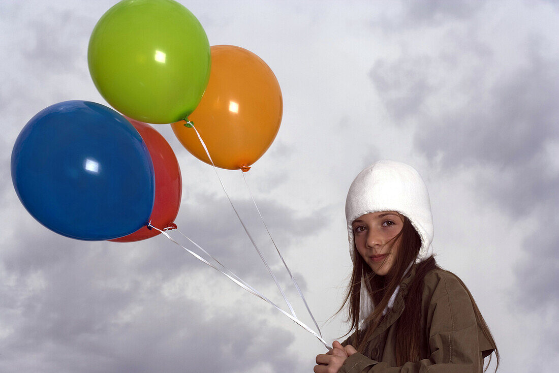 Female with balloons out on cloudy day