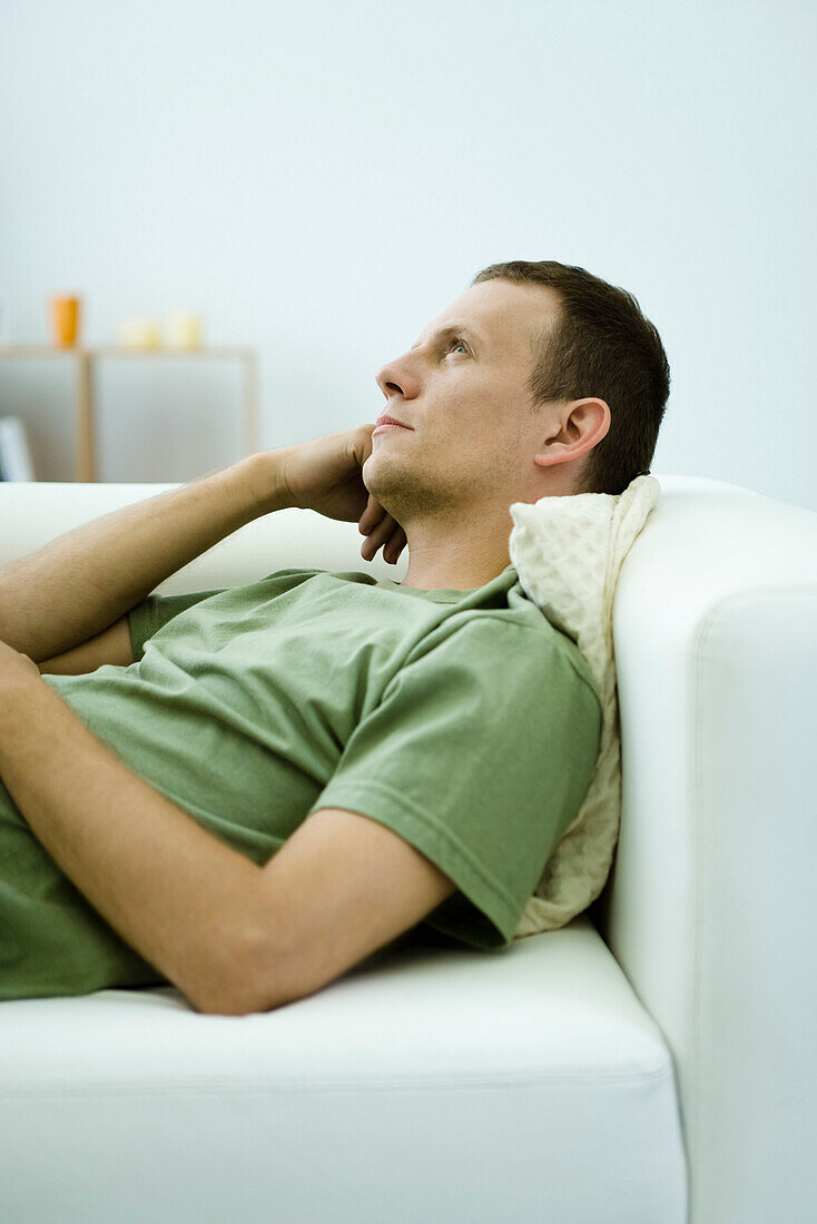 Man daydreaming on sofa