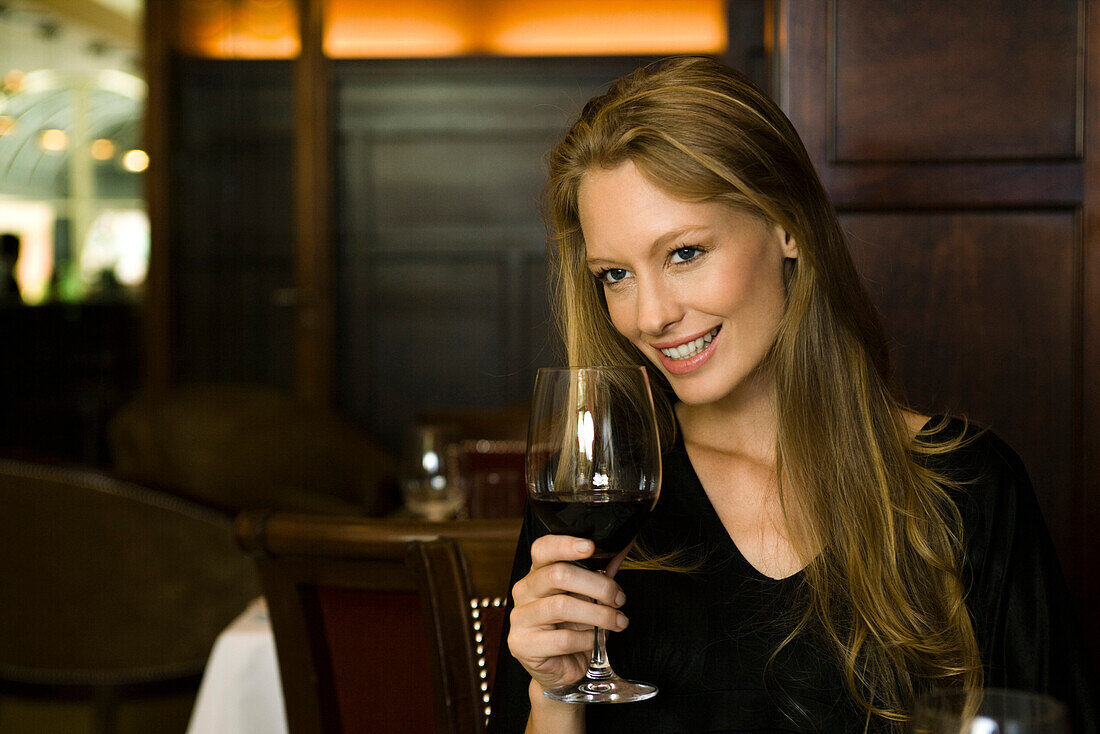 Woman enjoying glass of red wine in restaurant