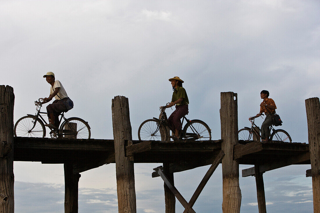 Amarapura, Myanmar, people cycling across U Bein Bridge