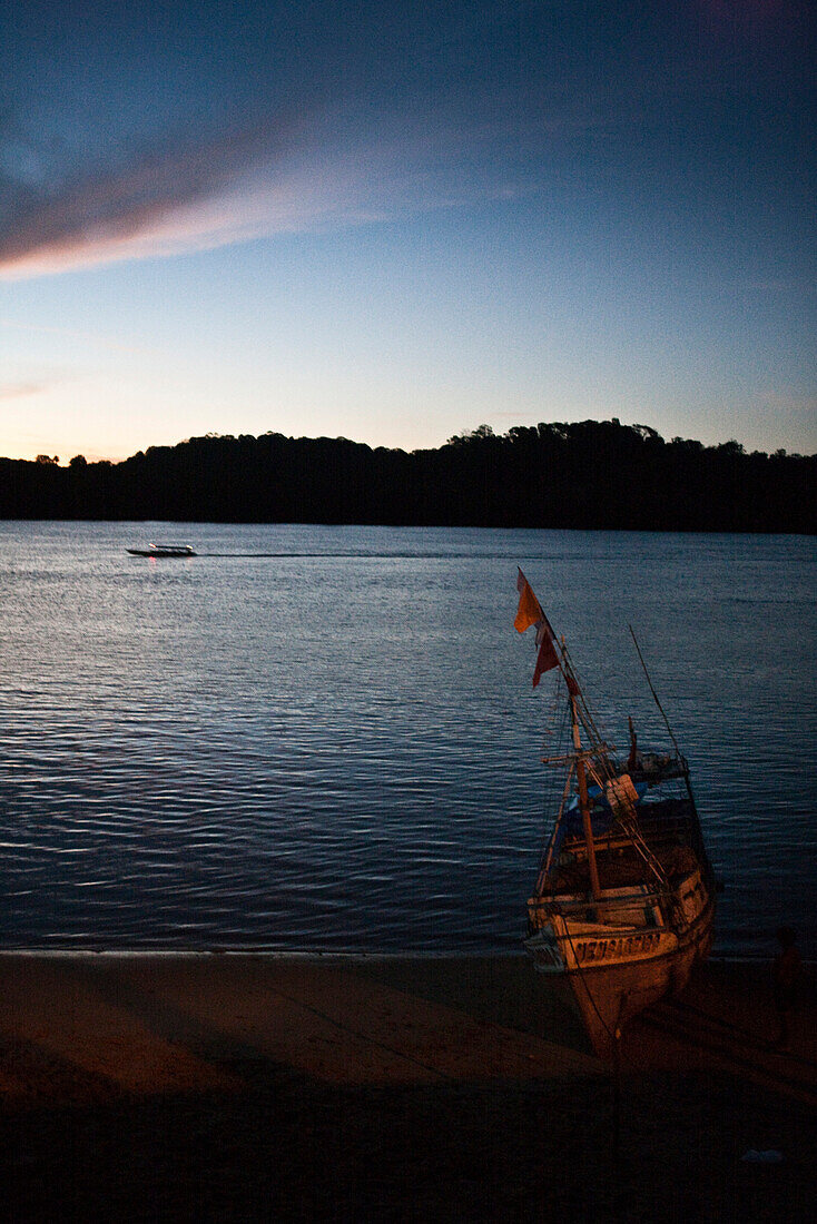 South America, Amazon, fishing boat on beach at dusk