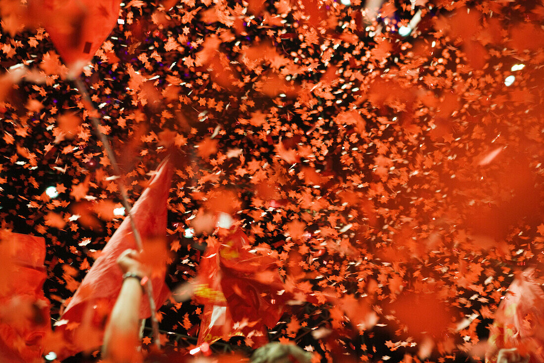 Crowd cheering, flags and confetti in air