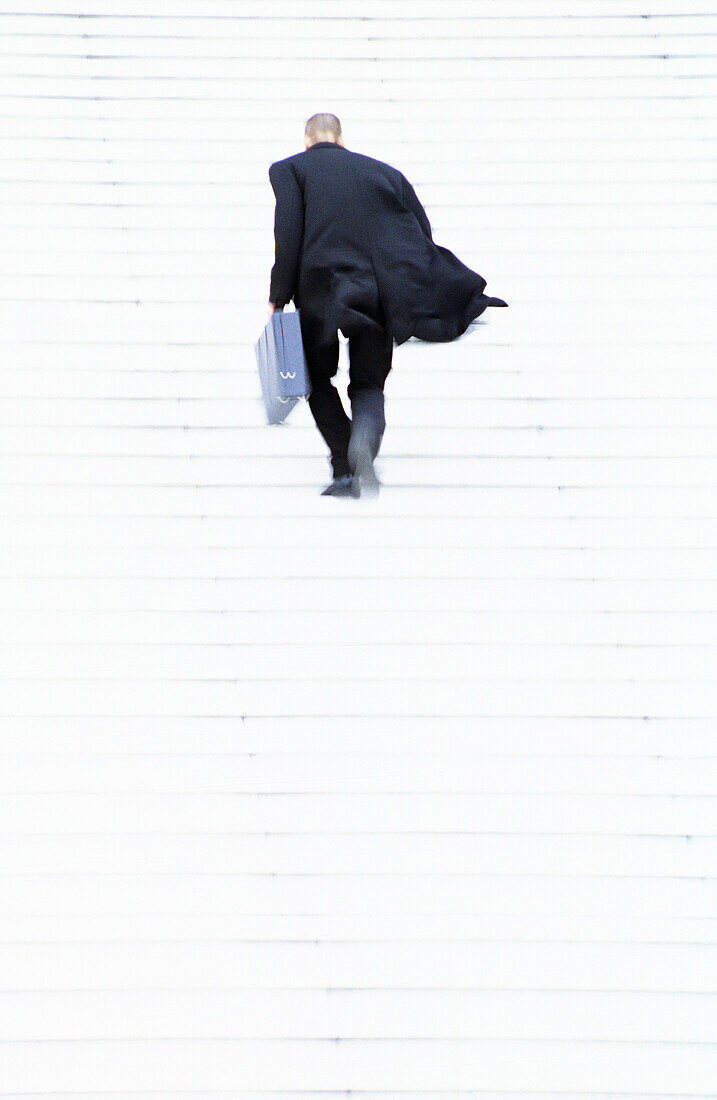 Businessman walking up steps, motion, full frame