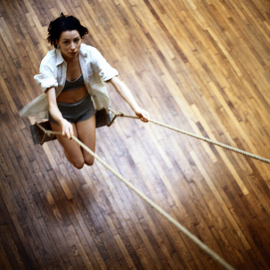 Young woman on swing, indoors, high angle view