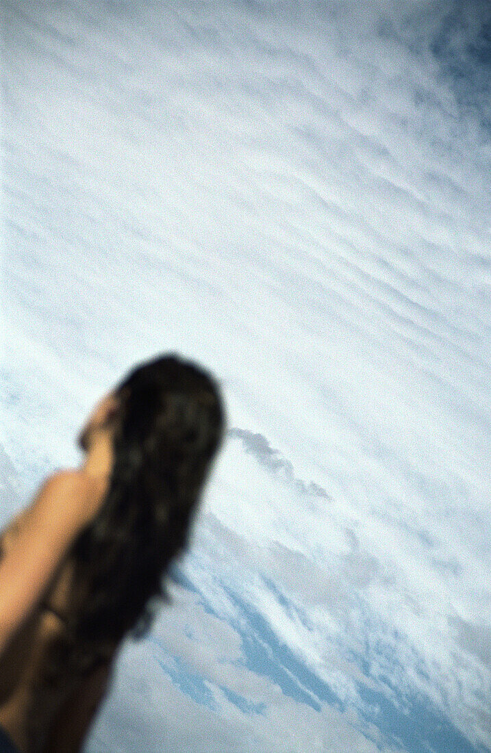 Woman with long hair, in front of sky