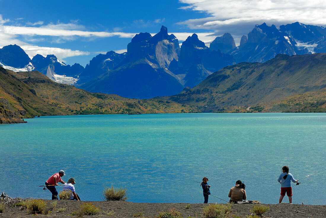 Chile, Patagonia, Torres del Paine National Park, Lake Pehoe, family fishing, Las Torres mountain in background