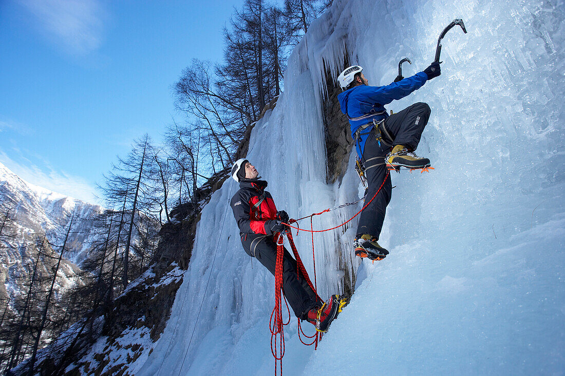 France, Alps, two alpinists climbing a waterfall of ice in the valley of Champsaur