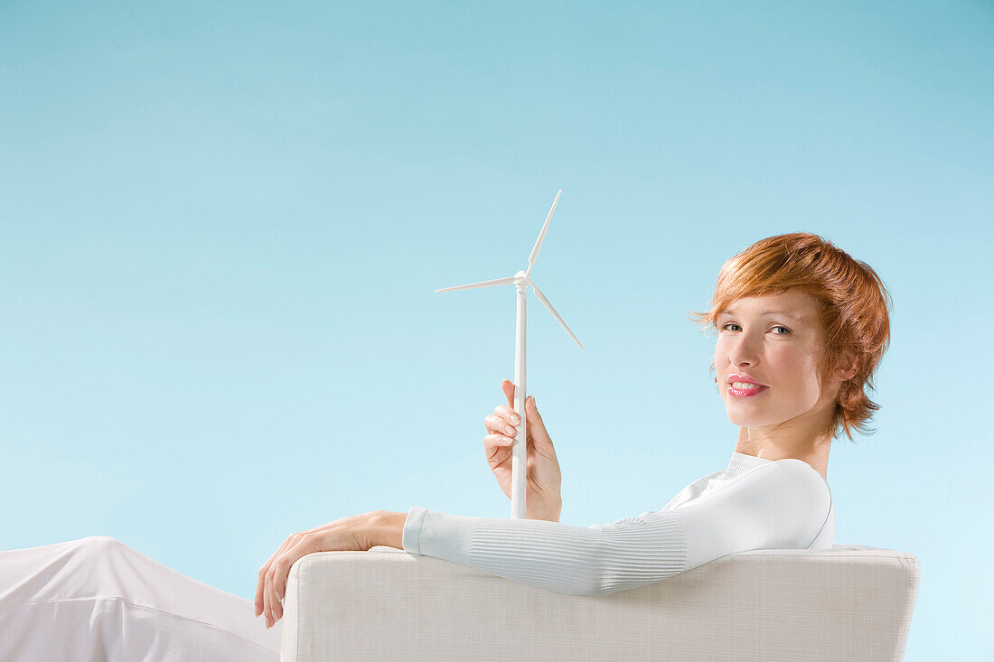 Claire looking at the camera, éolienne in hand in a clear blue background