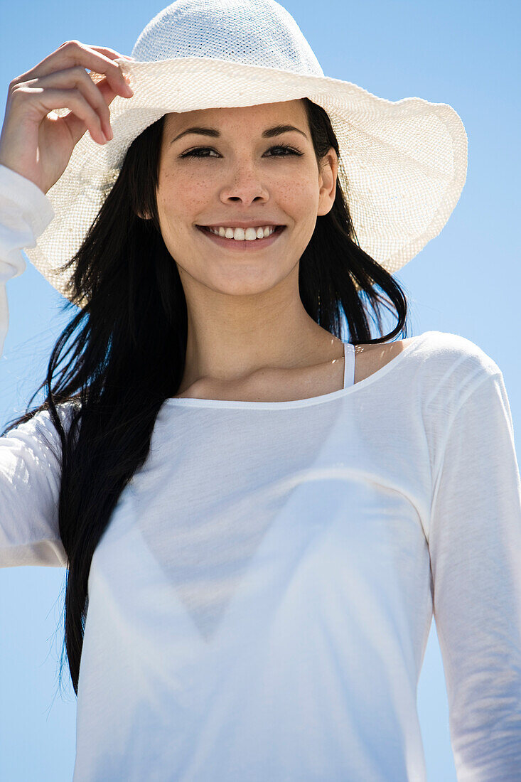 Portrait of young smiling woman, white hat