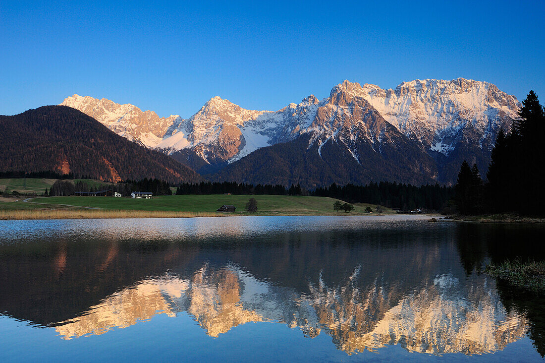 Verschneite Karwendelkette spiegelt sich in einem Bergsee, Krün, Werdenfelser Land, Bayerische Alpen, Oberbayern, Bayern, Deutschland