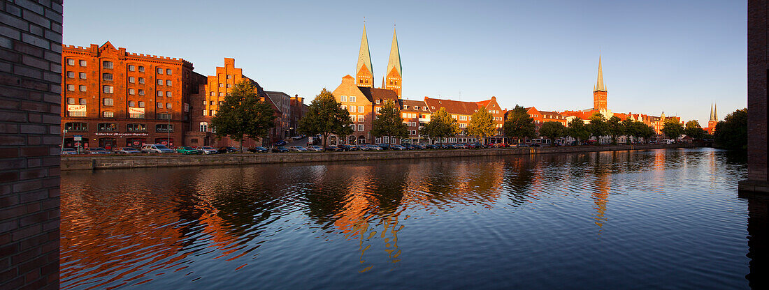 Panoramic view over the Trave river to the old town of Luebeck with old storehouses at the Holsten harbour, St Mary´s church and church of St Petri, Hanseatic city of Luebeck, Baltic Sea, Schleswig-Holstein, Germany