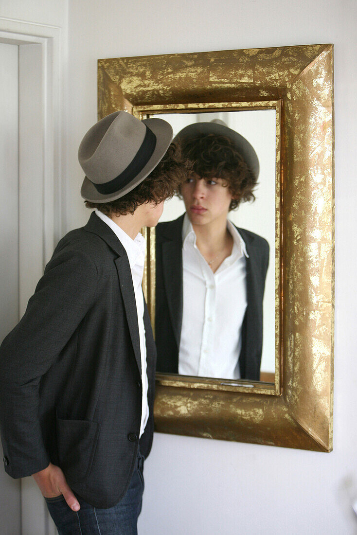 Teenage boy looking at himself in a miror