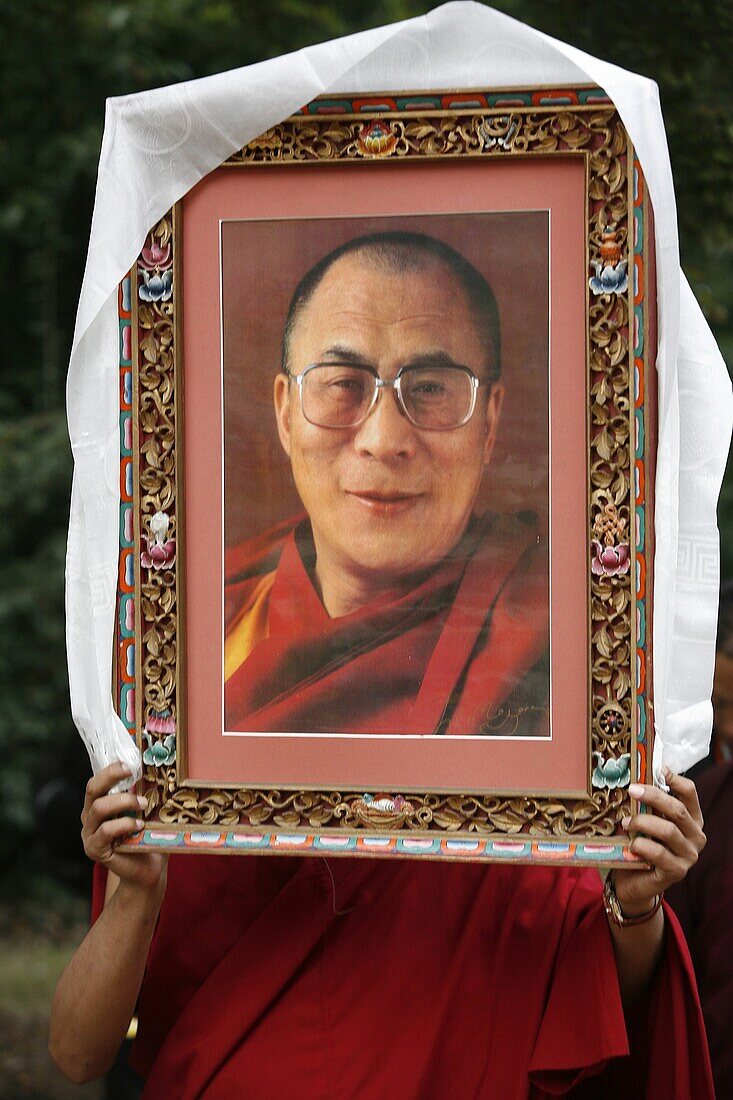 France, Paris, Buddhist holding a picture of the Dalaï Lama